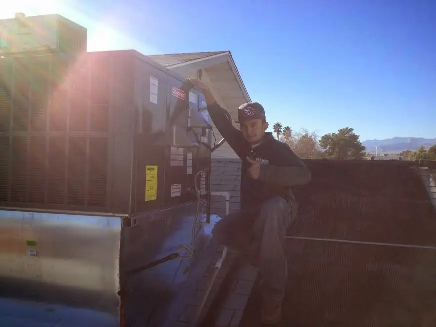 HVAC technician performing AC Tune-Up on a rooftop unit in Howell